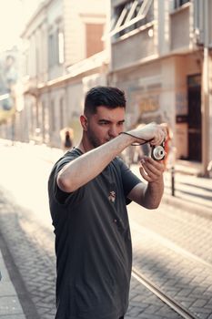 Young man capturing moments on a sunny street with a camera.