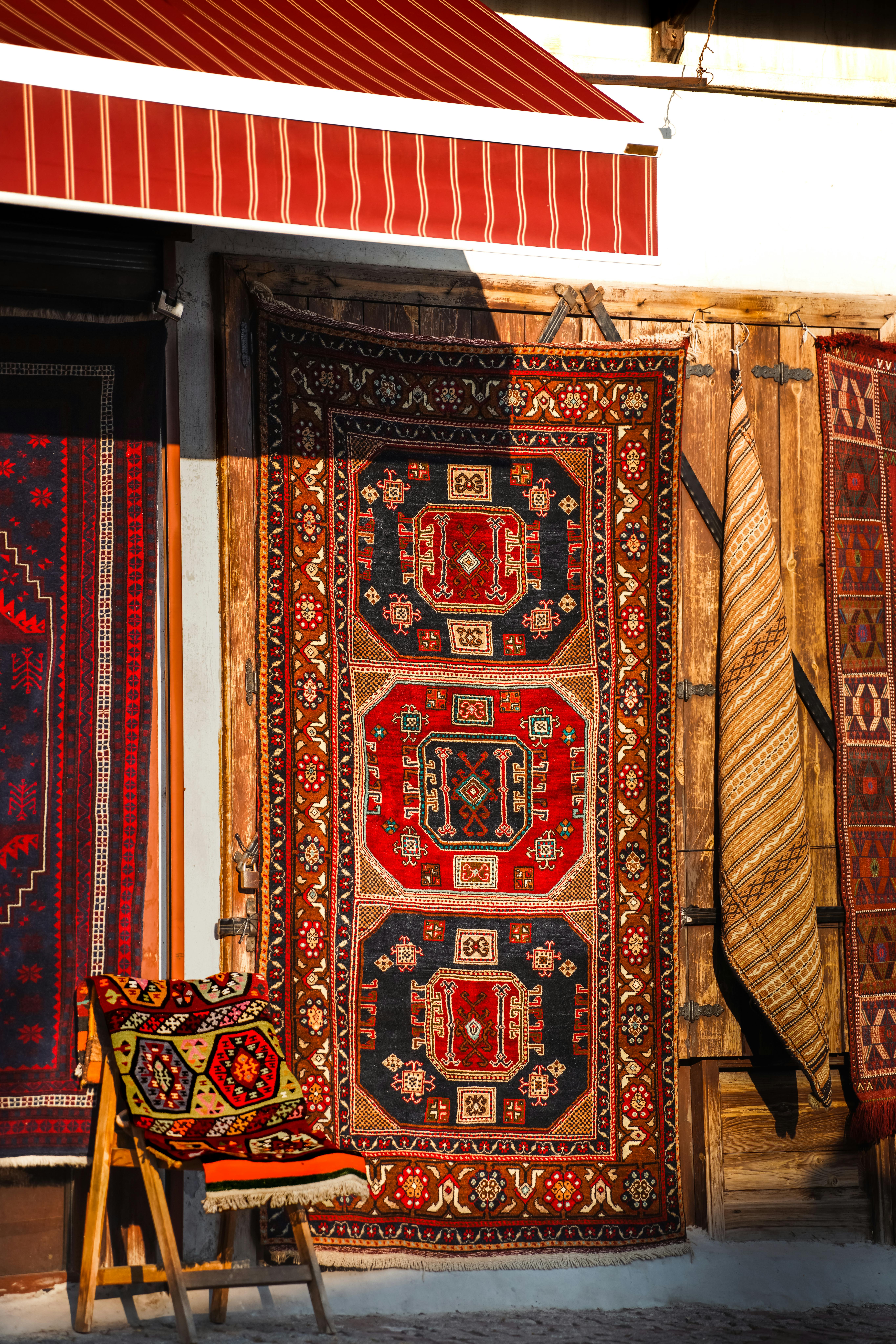 Colorful traditional Turkish rugs and textiles displayed in Ankara, Türkiye, during sunset.