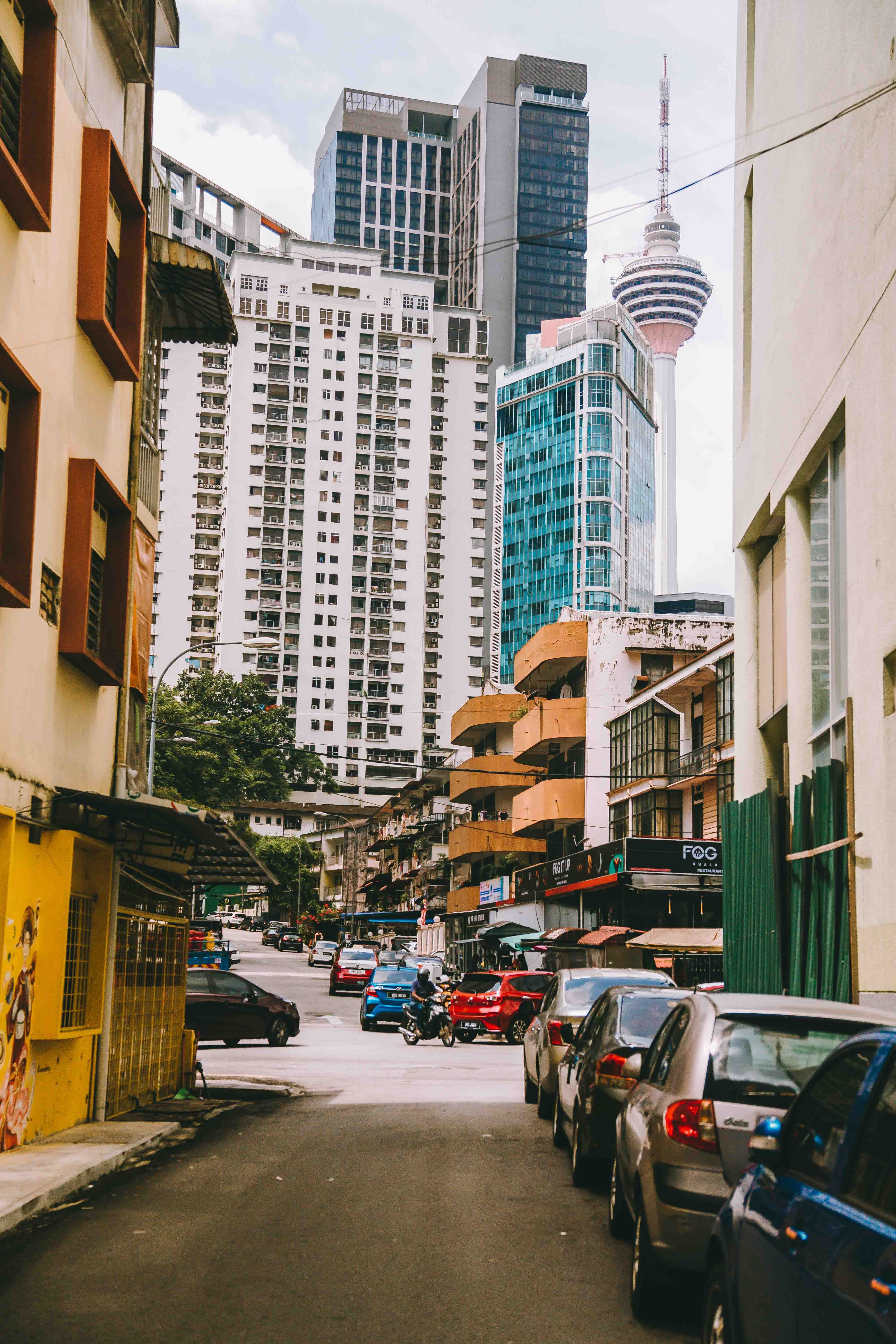 A street with cars parked in front of tall buildings · Free Stock Photo