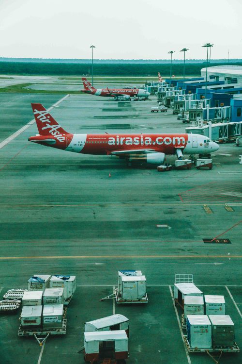 Free AirAsia planes docked at Kuala Lumpur International Airport terminal, ready for boarding. Stock Photo