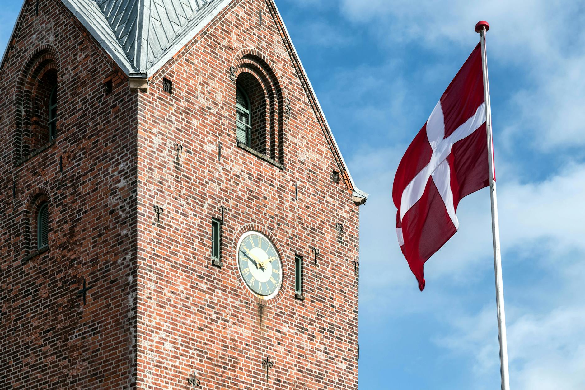 https://www.pexels.com/photo/danish-flag-in-front-of-brick-clock-tower-27156135/