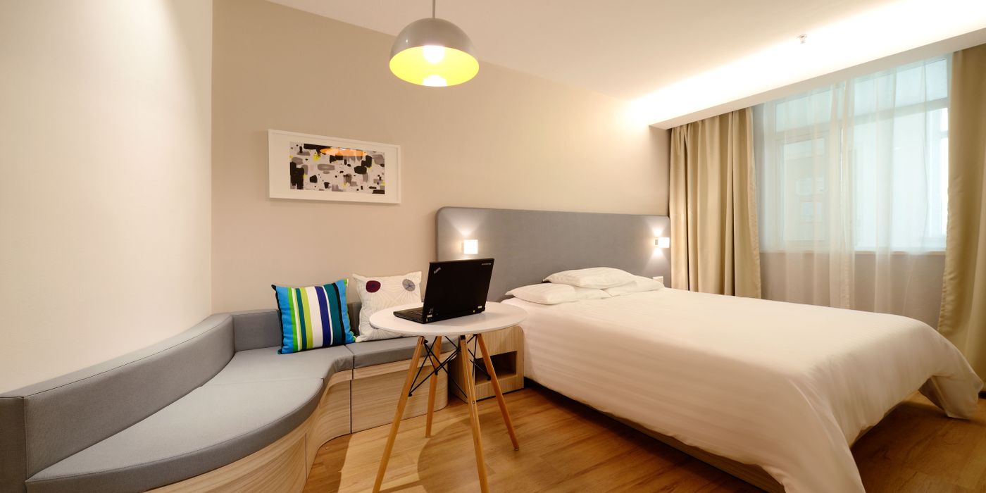 Mid-tier hotel guest room with two beds and modern furnishings
