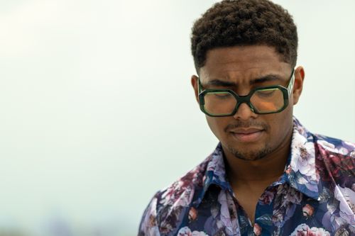 Free Stylish man with green sunglasses and floral shirt outdoors, showcasing a cool fashion style. Stock Photo