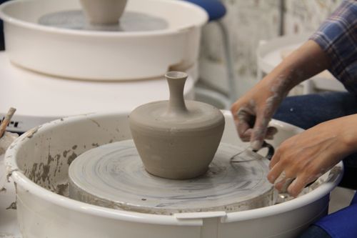 Free Close-up of hands skillfully shaping clay pottery on a wheel in a creative studio setting. Stock Photo