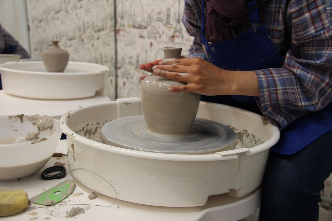 Mains façonnant un vase sur un tour de potier