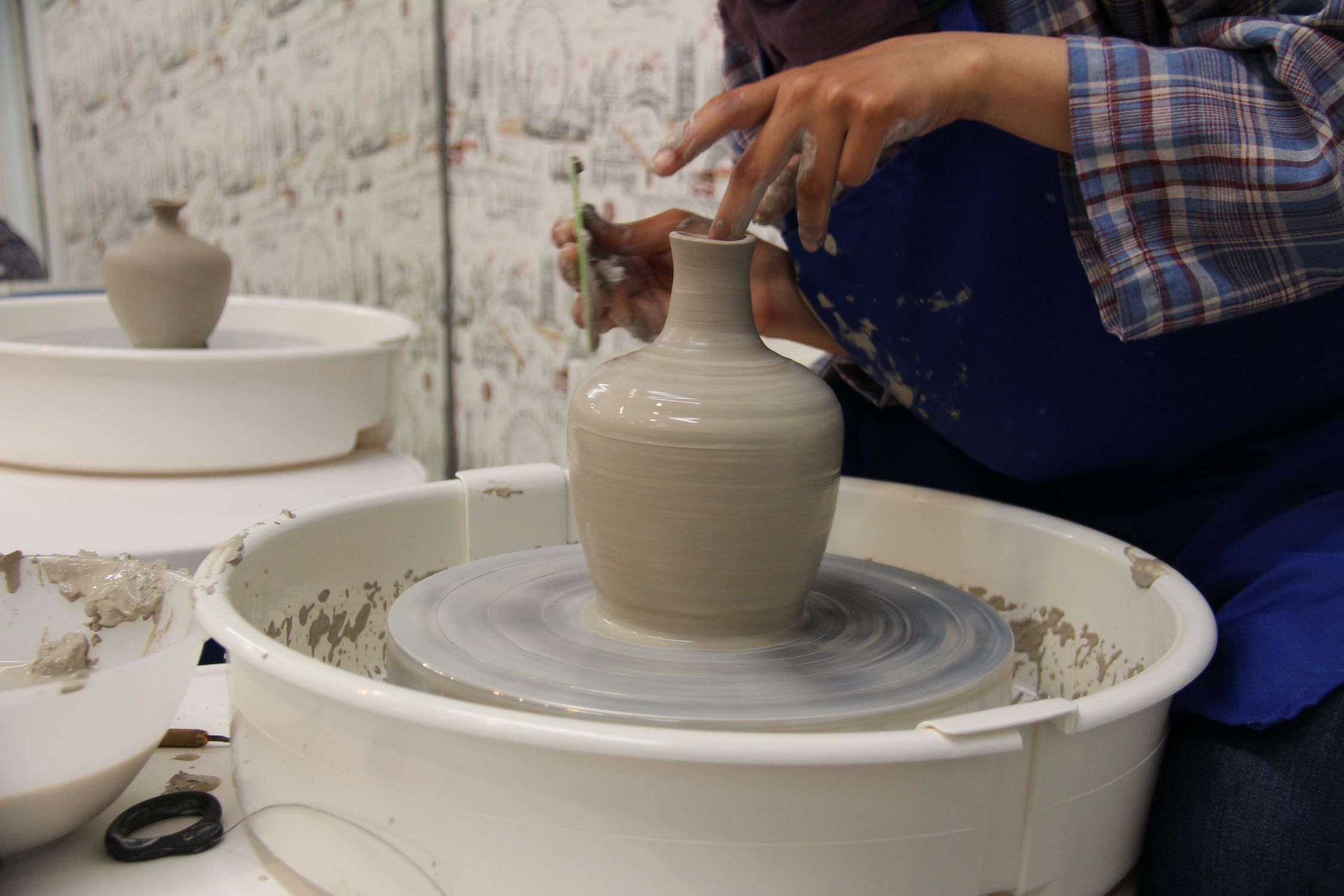 A woman is making a pottery on a wheel · Free Stock Photo