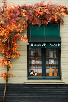 Traditional Japanese restaurant facade with autumn leaves and vibrant decor.