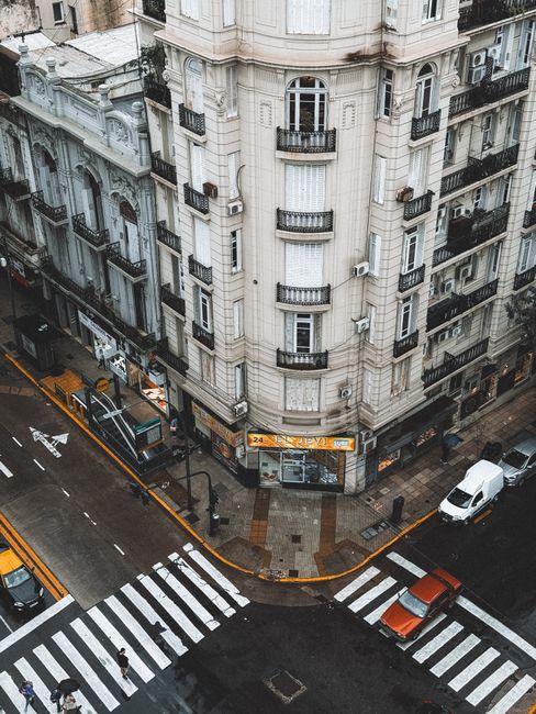 A bustling street corner in Buenos Aires featuring classic architecture and vibrant urban life.