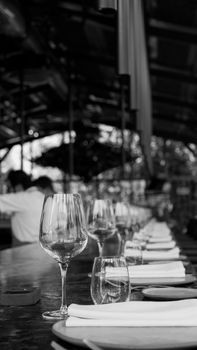 A sophisticated black and white photograph of a set dining table in a modern restaurant.