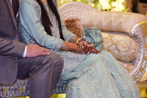 Free A couple in traditional South Asian wedding attire at a ceremony, featuring intricate designs. Stock Photo