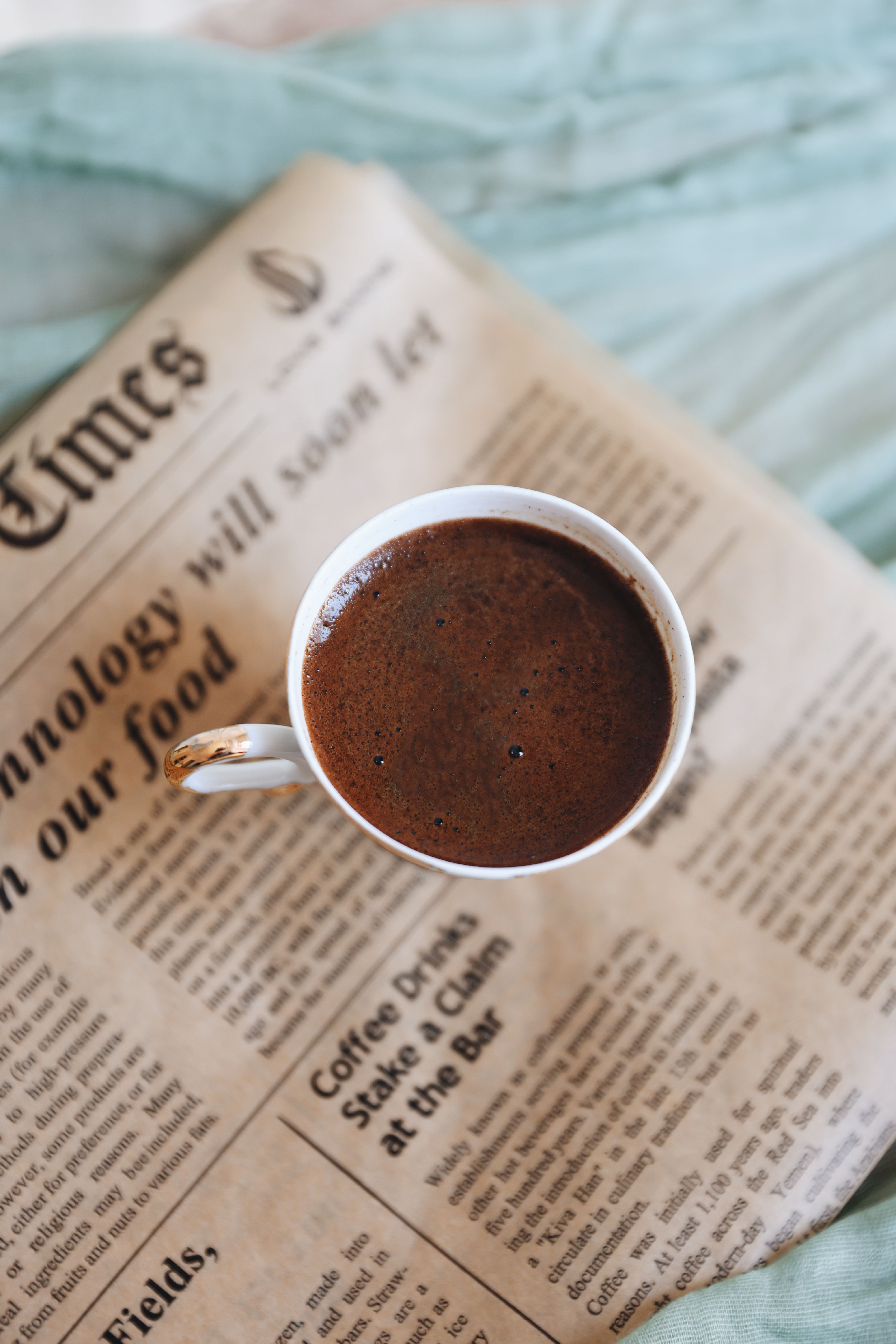 A cup of coffee resting on a newspaper