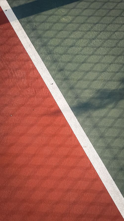 Free Abstract view of a tennis court surface showing textured ground and shadows. Stock Photo