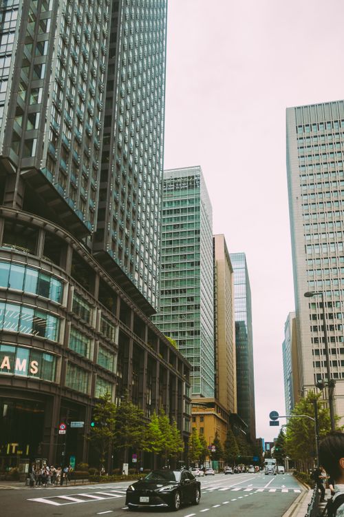 Free Bustling urban street surrounded by towering modern skyscrapers in downtown area. Stock Photo