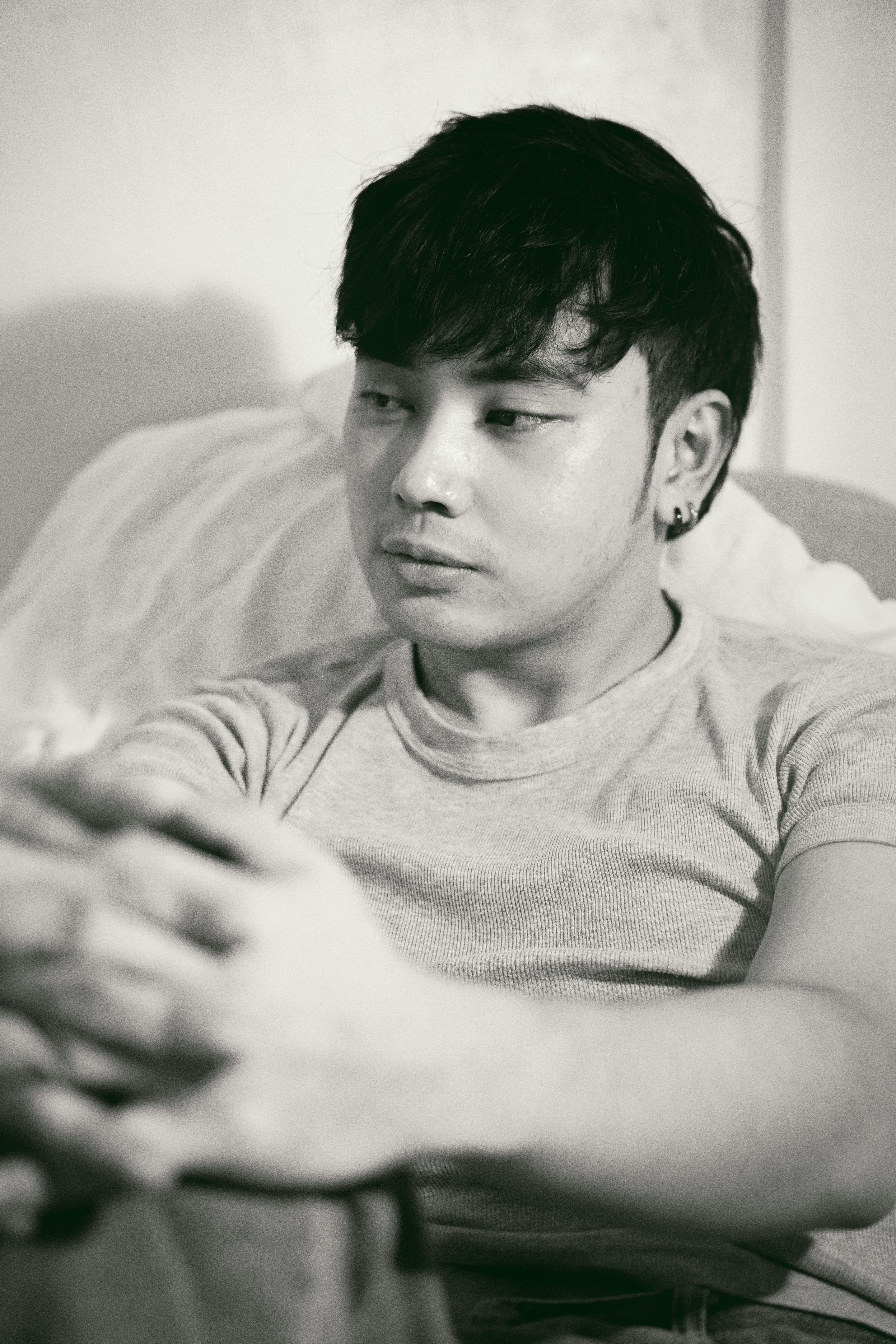 man sitting on bed in black and white