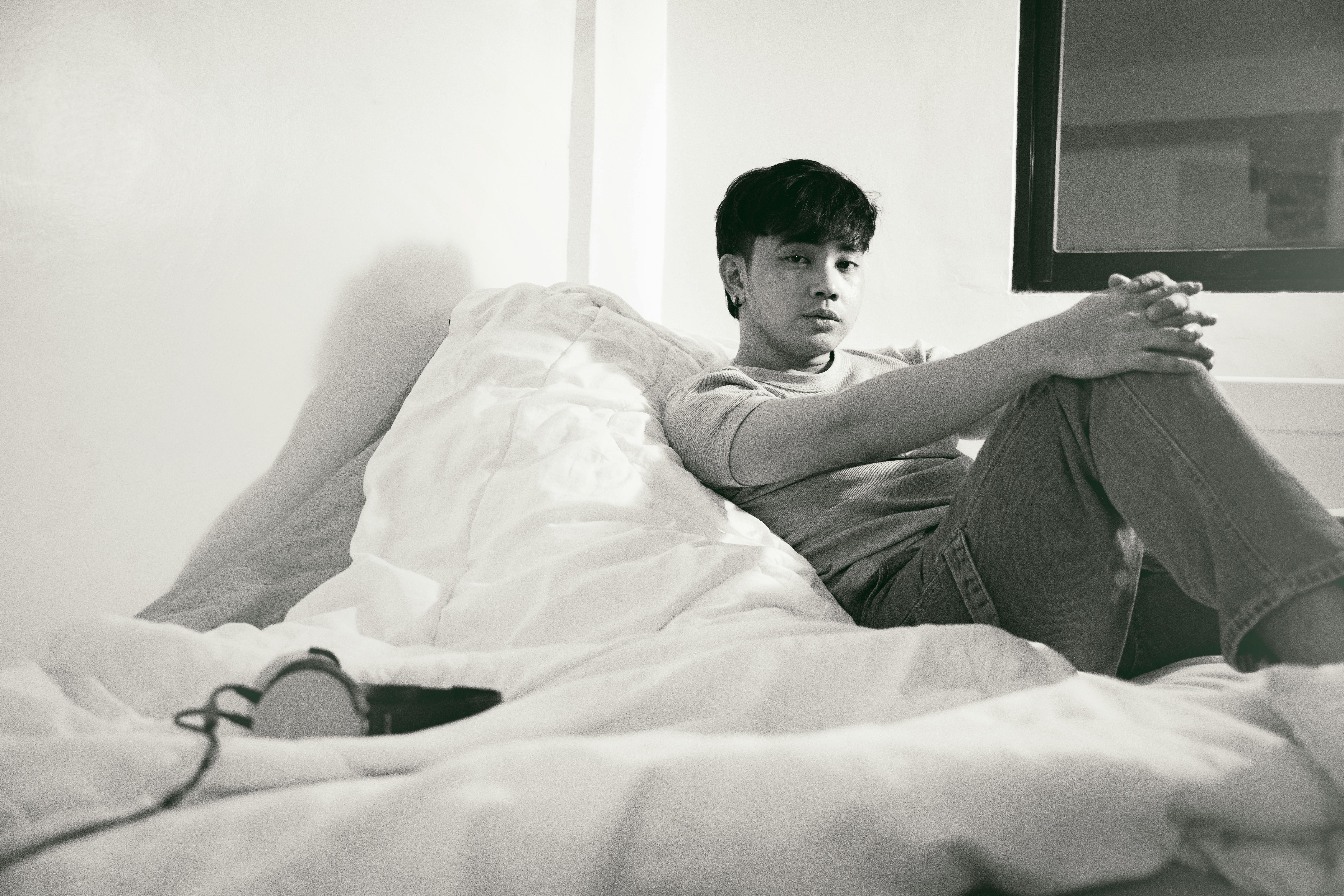 man lying on bed in black and white