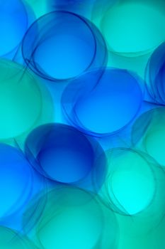 Vibrant abstract circles in blue and green swirls create a dynamic pattern.