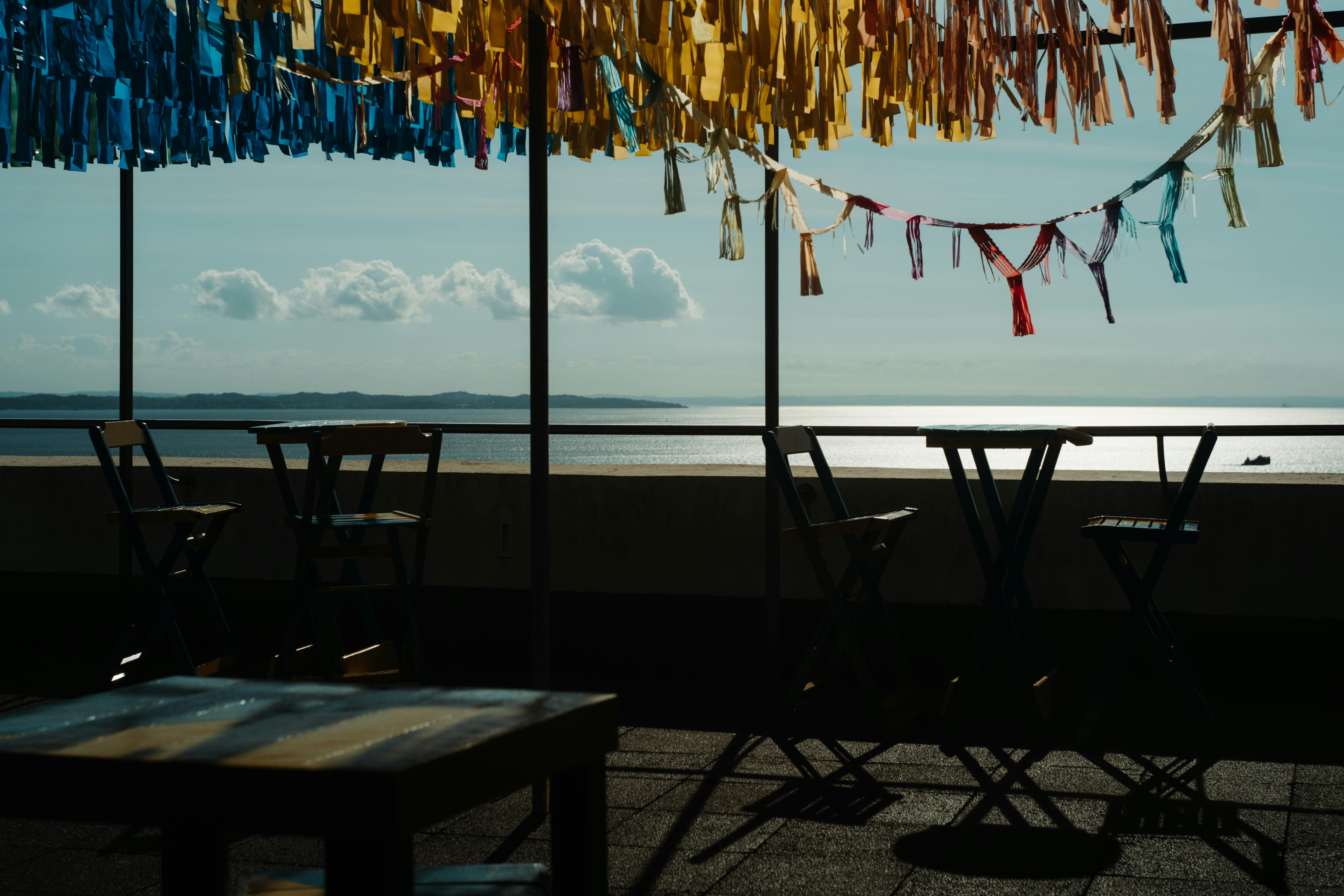 tables and chairs on terrace on seashore