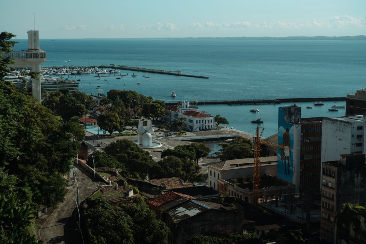 Captivating aerial shot of Salvador's harbor with clear blue sky and boats docked by the bay.