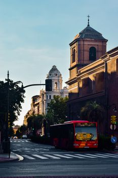 Urban scene in Zaragoza, Spain showcasing historical buildings and city transport on a sunny day.