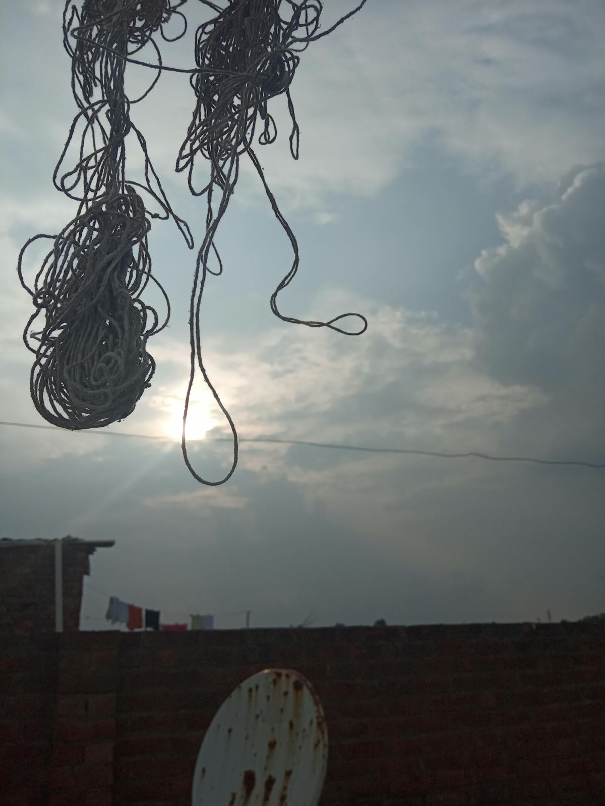 A close-up of a Mediterranean grain bowl topped with roasted vegetables, chickpeas, herbs, and lemon wedges.