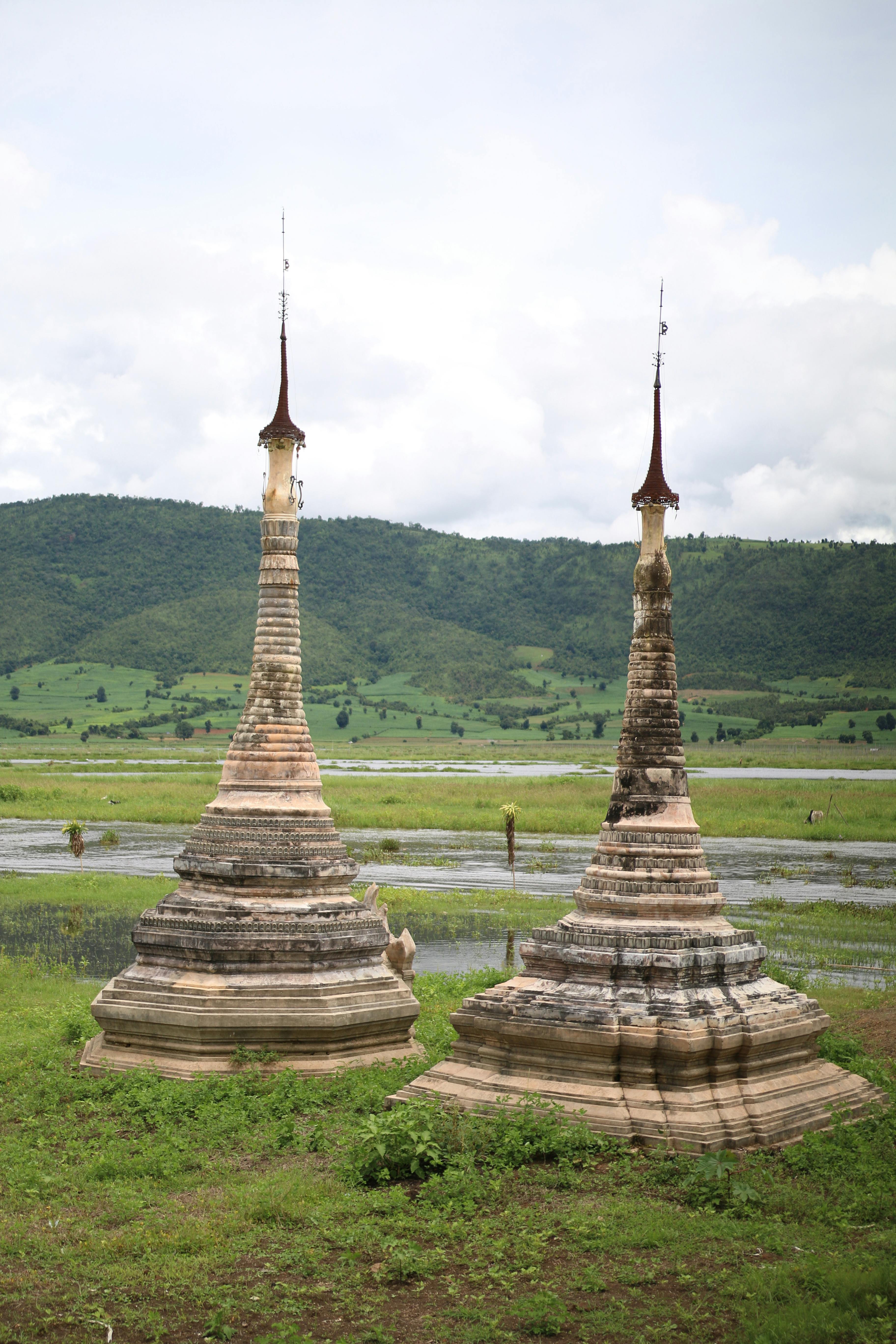 Two ancient pagodas stand majestically in the serene landscape of Inle, Myanmar, showcasing rich cultural heritage.
