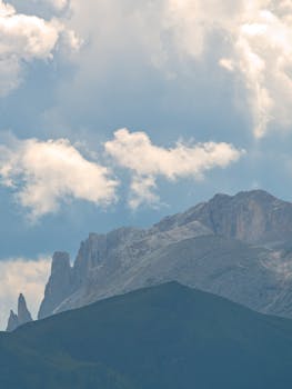 Breathtaking view of the Dolomites in Santa Cristina Valgardena, Italy, under a stunning cloudy sky.