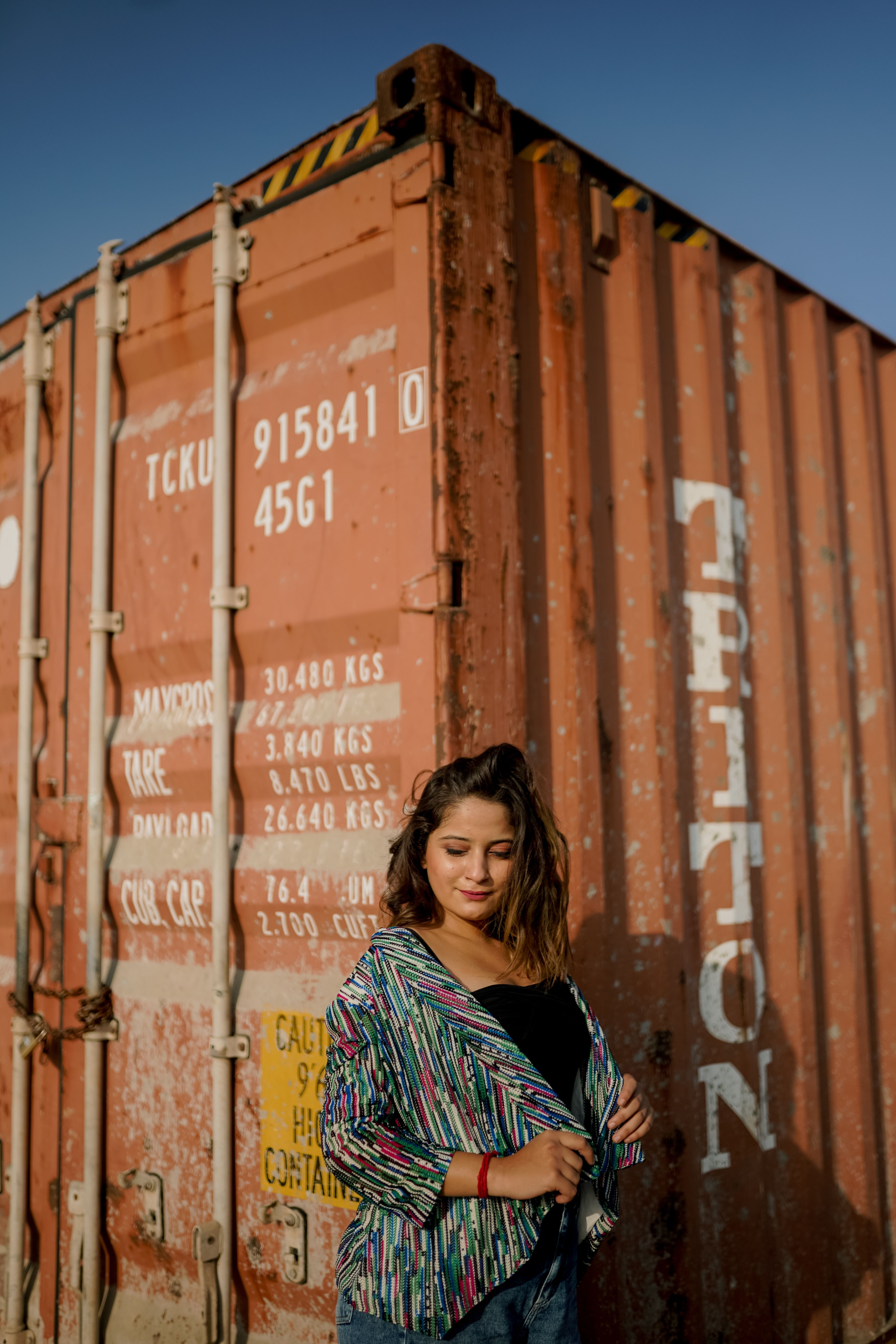 A Woman Standing by a Shipping Container · Free Stock Photo