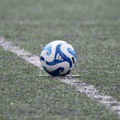 White and blue football on an artificial pitch beside the touchline