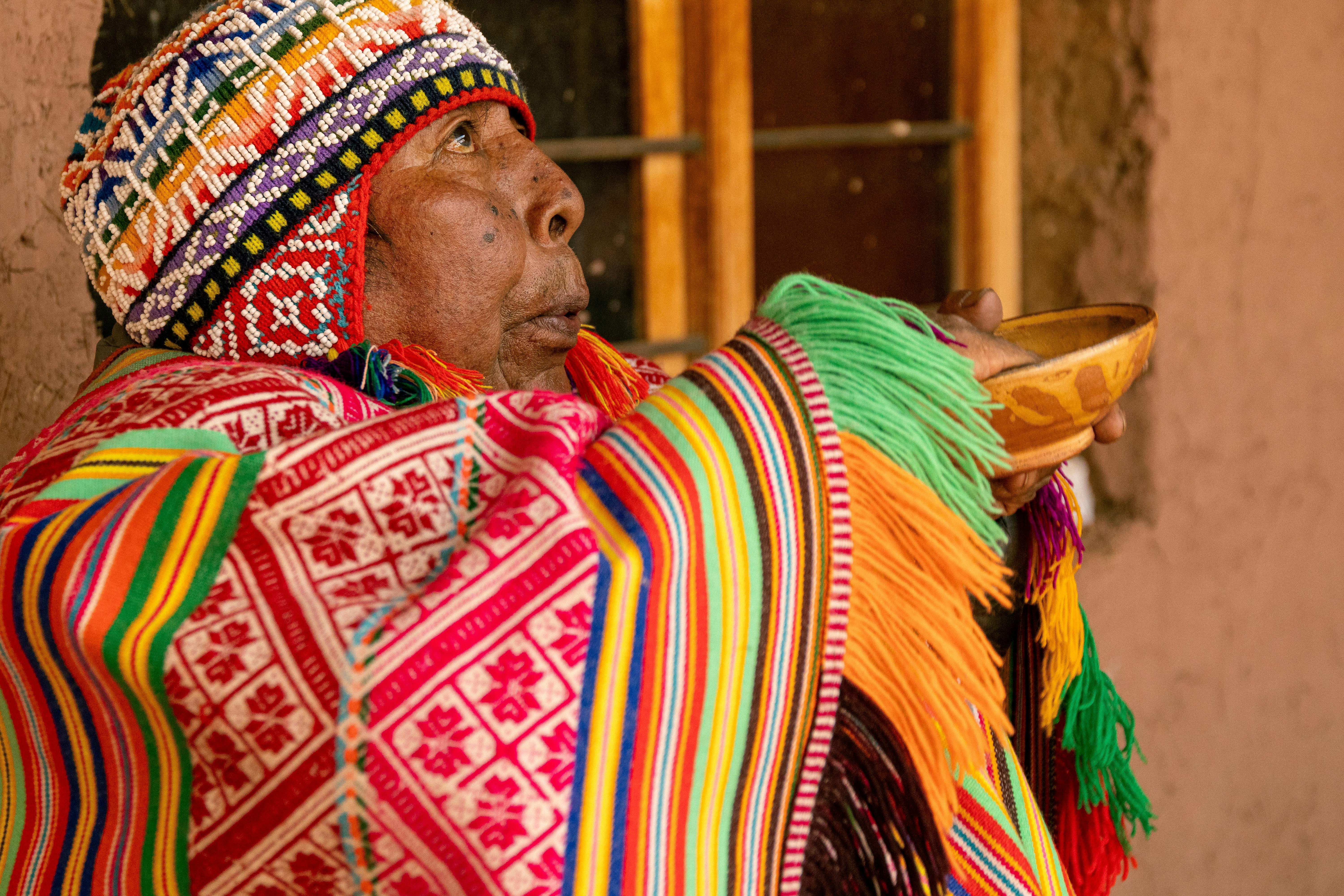 a woman in a colorful dress is holding a bowl