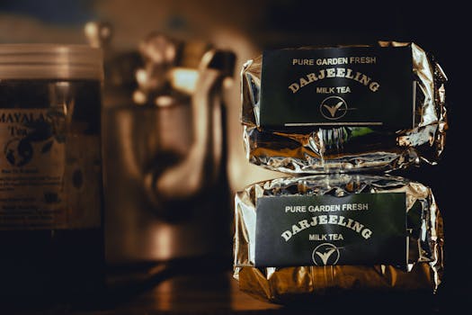 Elegant display of Darjeeling Milk Tea packs with metallic shimmer in an ambient setup.