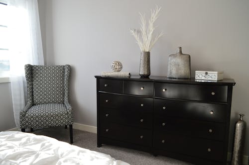 Free Gray and Black Chair Beside Black Wooden Lowboy Dresser Stock Photo