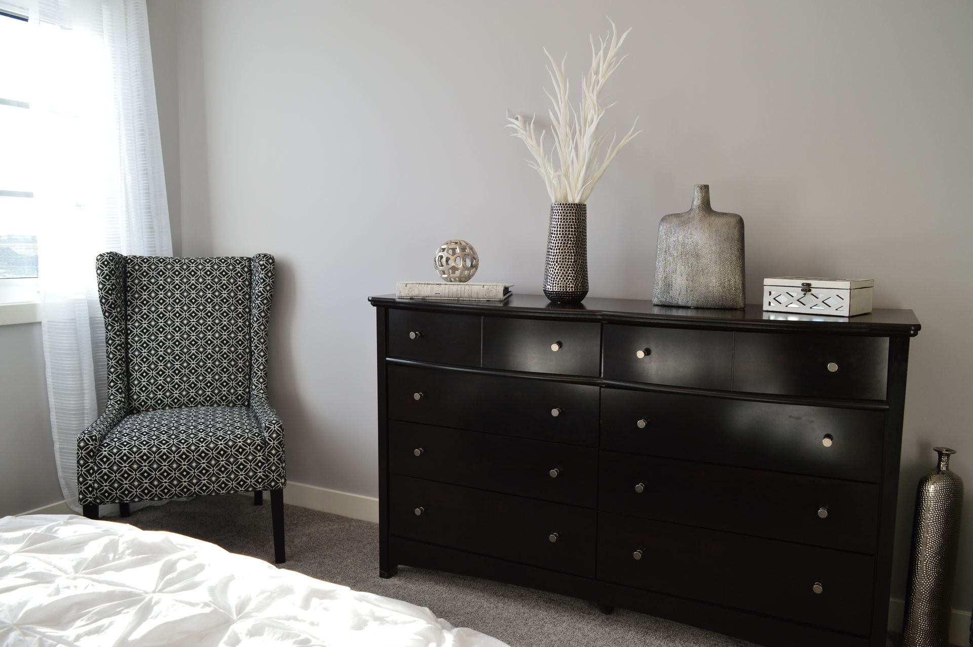 Gray and Black Chair Beside Black Wooden Lowboy Dresser