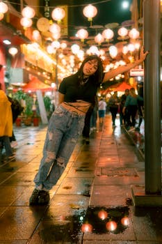 A young woman poses under festive string lights in Mexico City's vibrant Chinatown street at night.