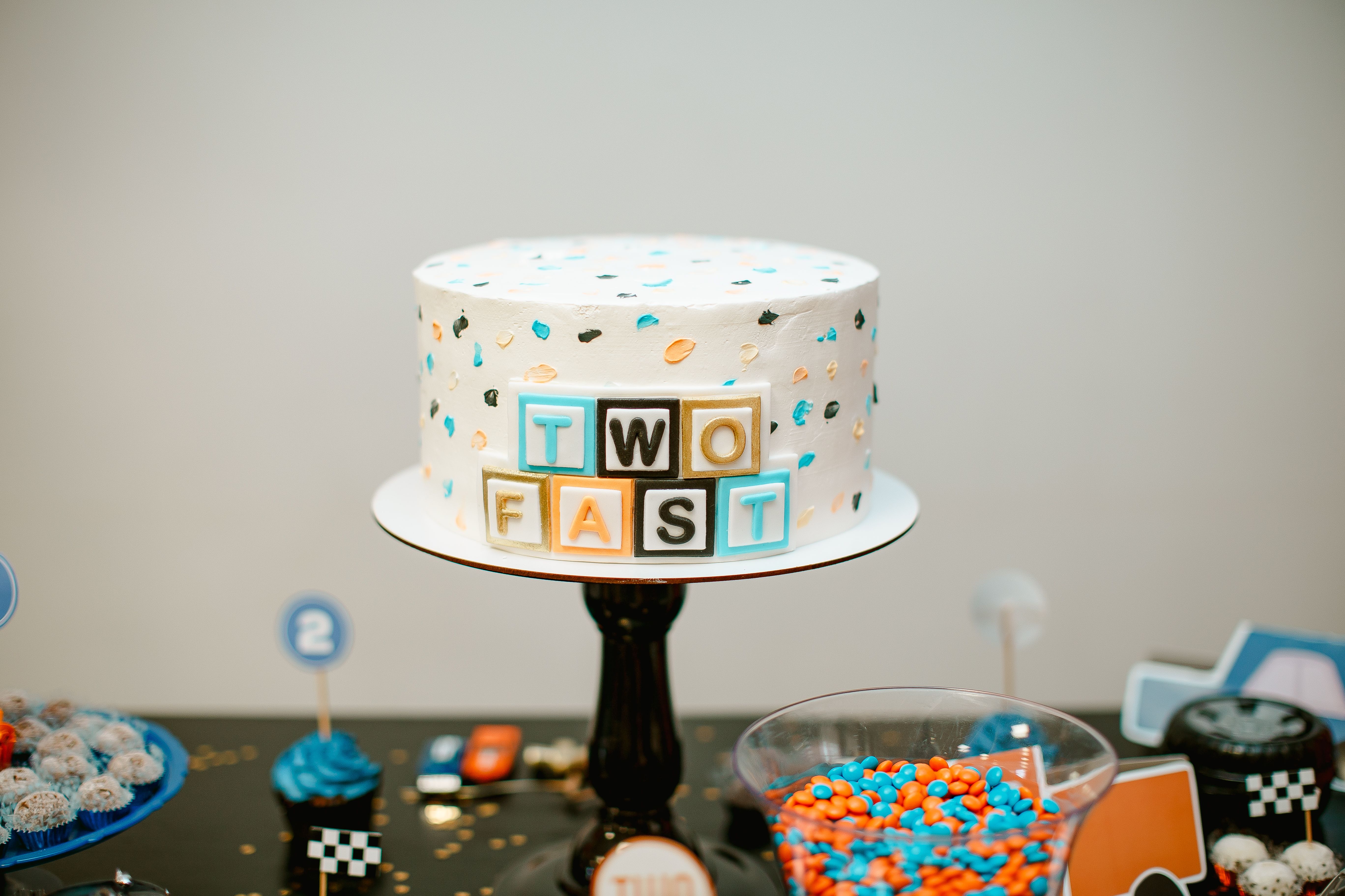 Colorful 'Two Fast' themed cake at a racing birthday party setup.