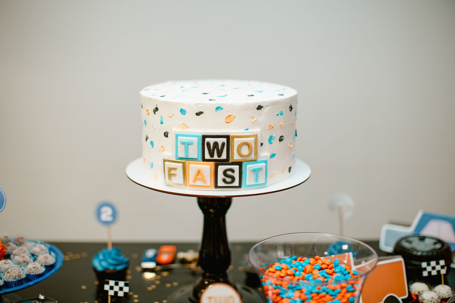 Colorful 'Two Fast' themed cake at a racing birthday party setup.