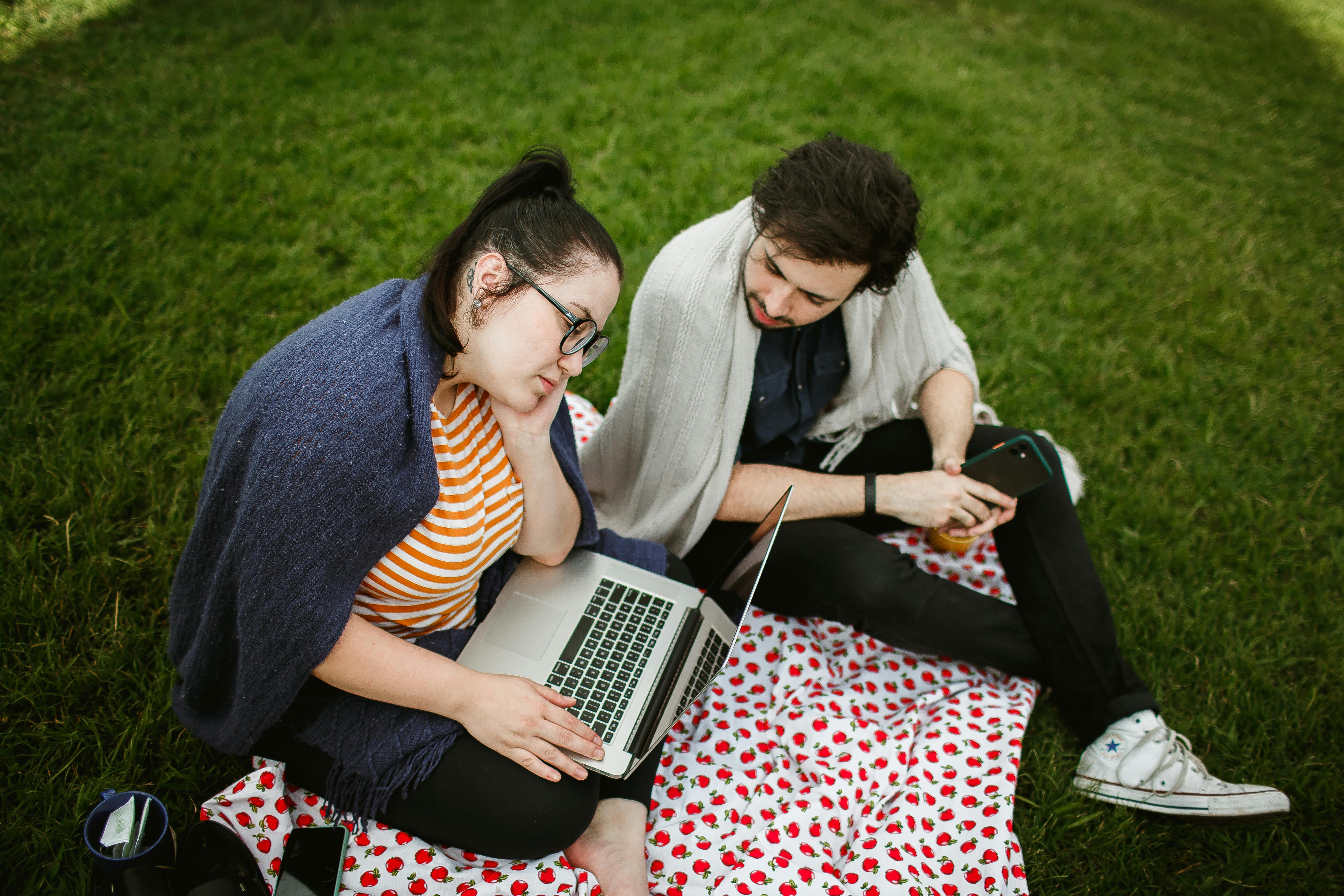 Young adults studying outdoors on a laptop