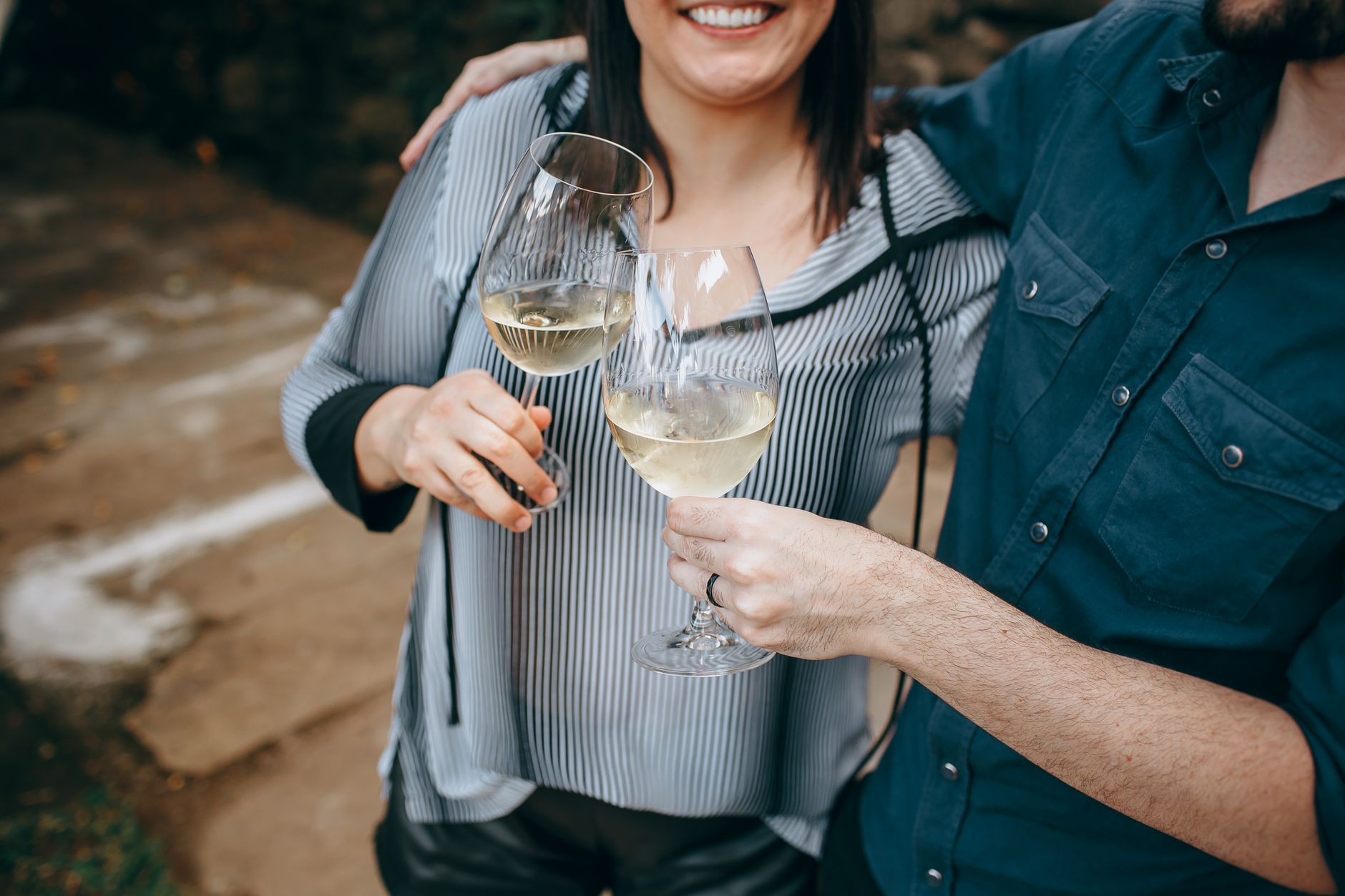 Person holding wine glass by the stem in formal setting