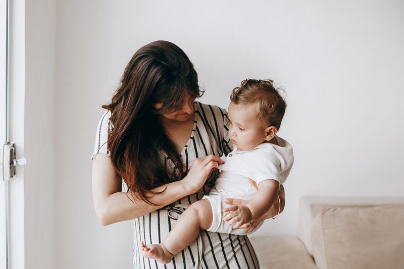 A tender moment between a mother and her baby indoors, showcasing love and care.