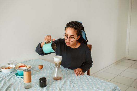 A woman pours coffee in a serene home setting, capturing a relaxing morning ritual.