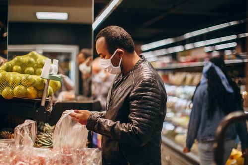 Free Man wearing mask shopping for fresh produce at a supermarket. Stock Photo