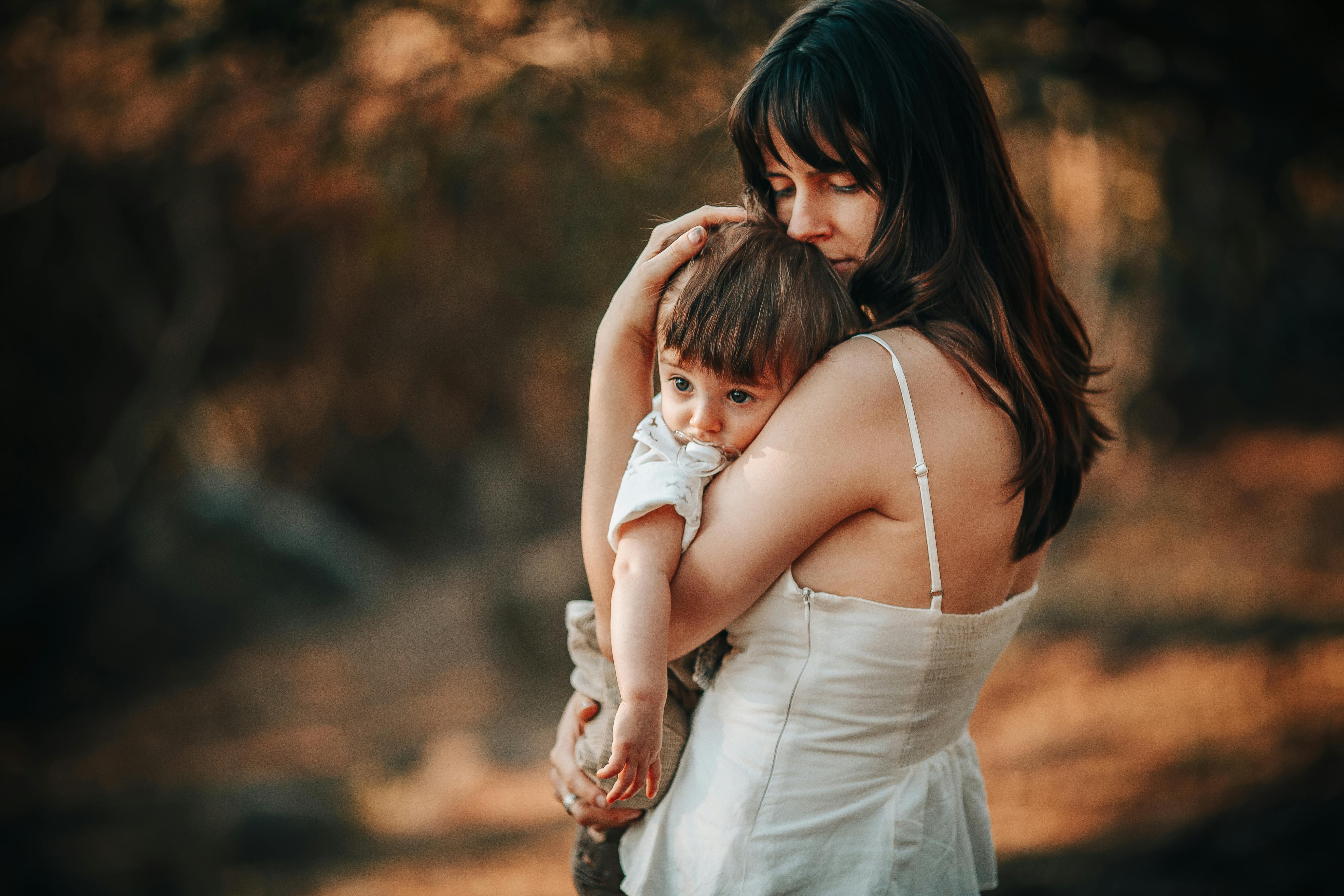 woman in dress standing with baby