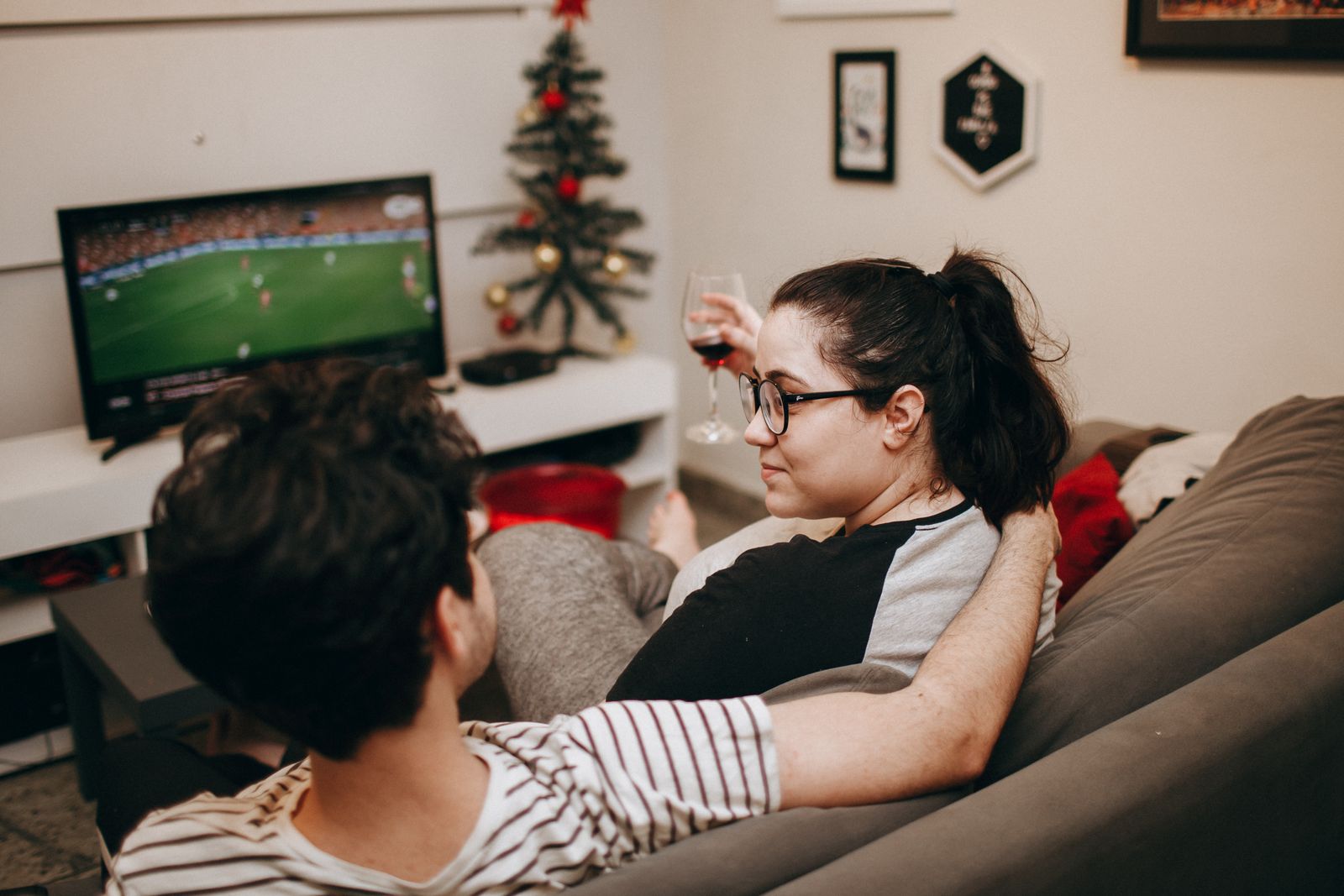 A couple relaxing on a sofa and watching television