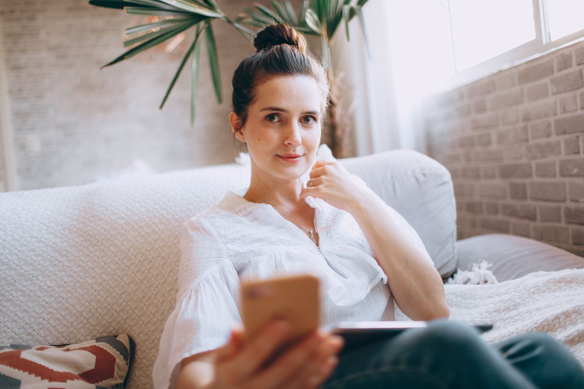 Member checking her Almanac results on a phone at home — photo by Helena Lopes on Pexels