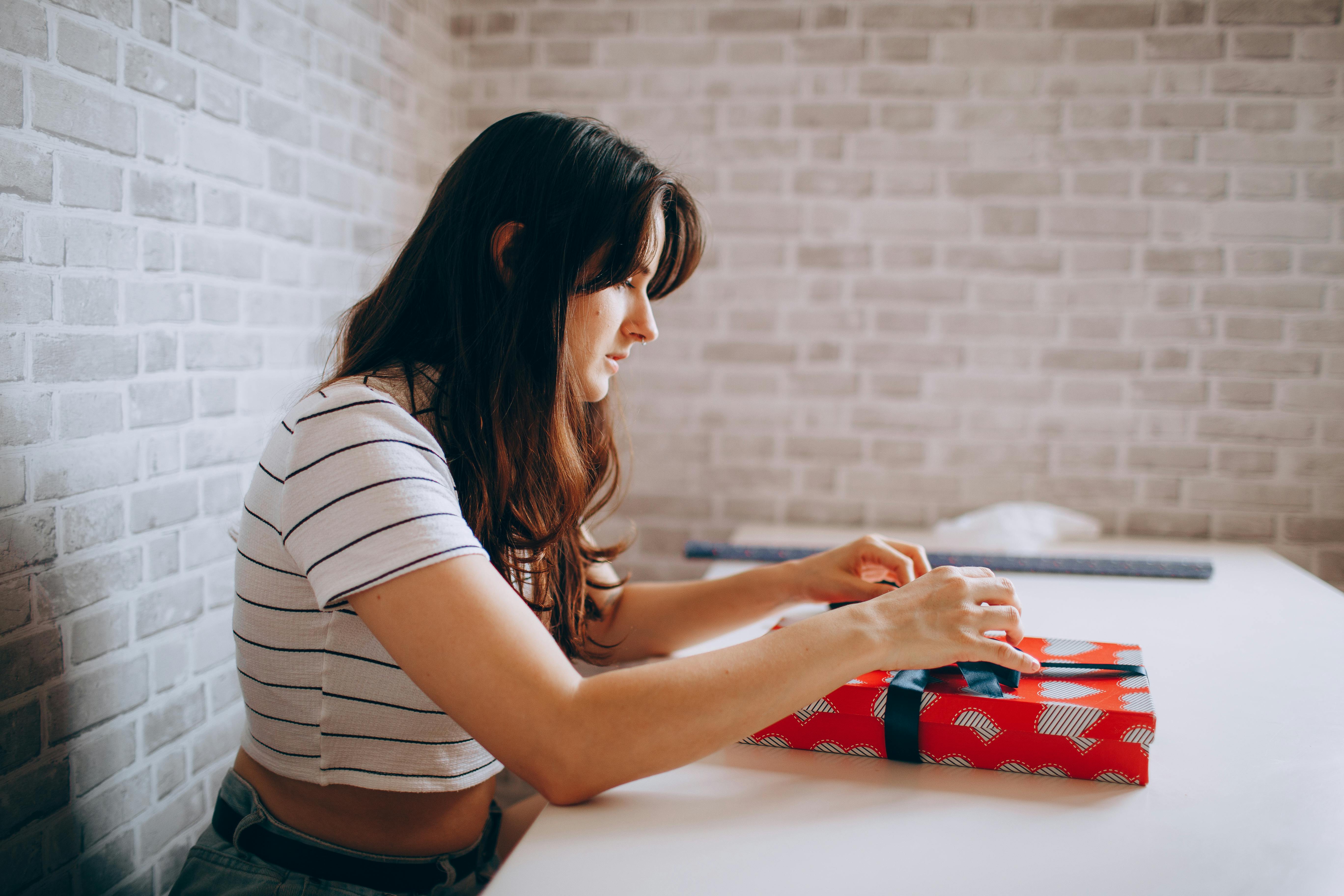 woman sitting and wrapping gift