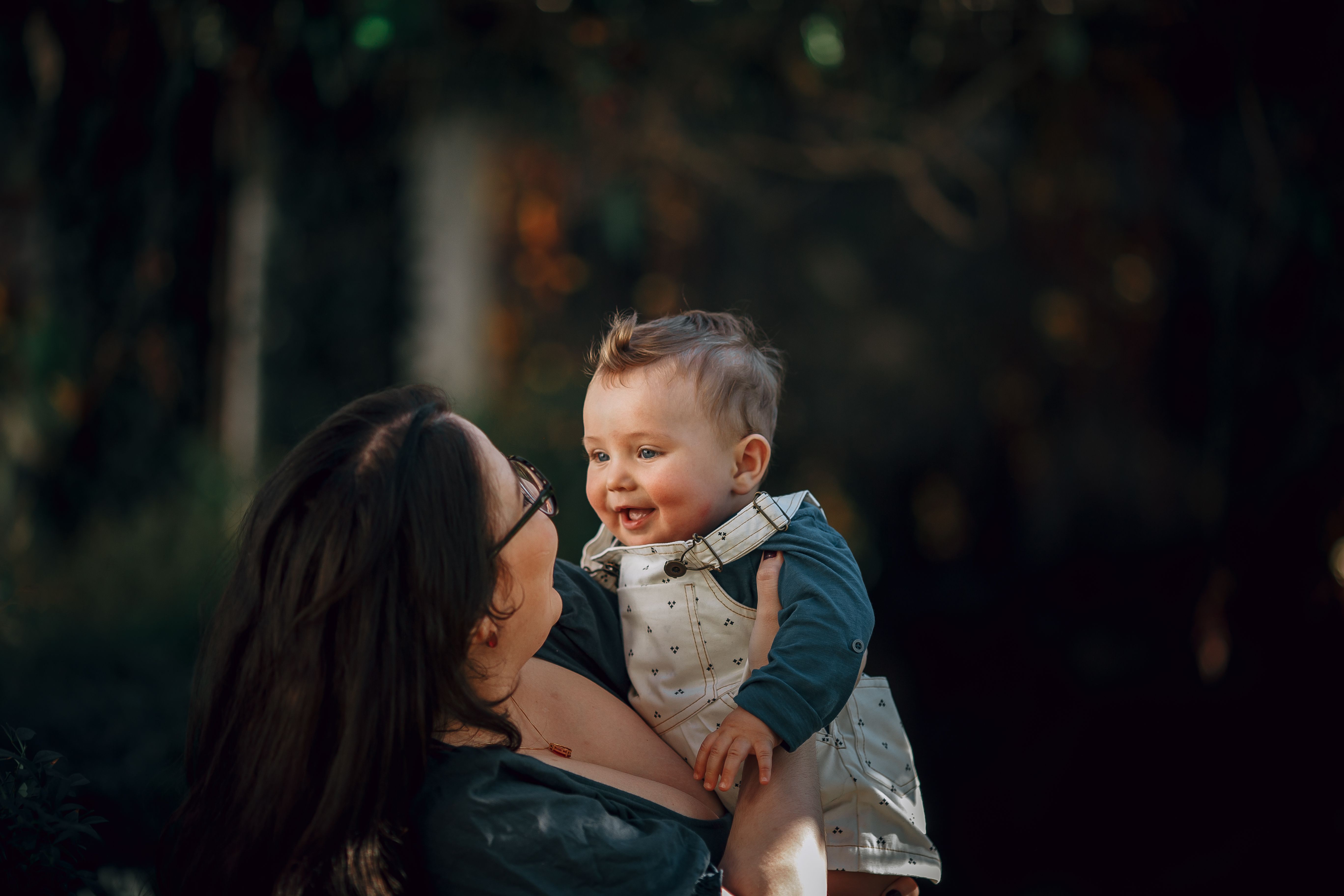 A woman holding a baby and smiling at the camera · Free Stock Photo