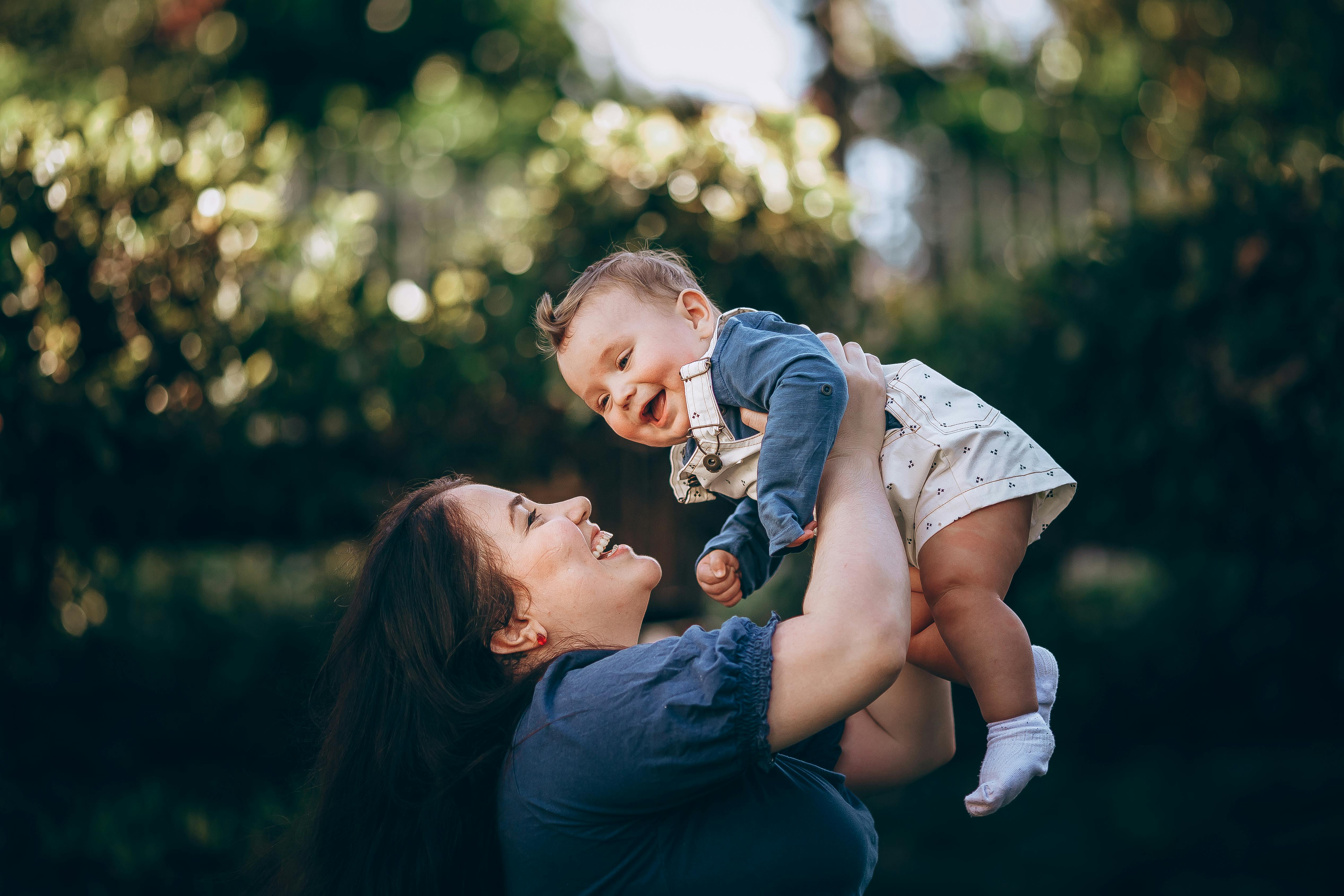 A woman holding her baby up in the air