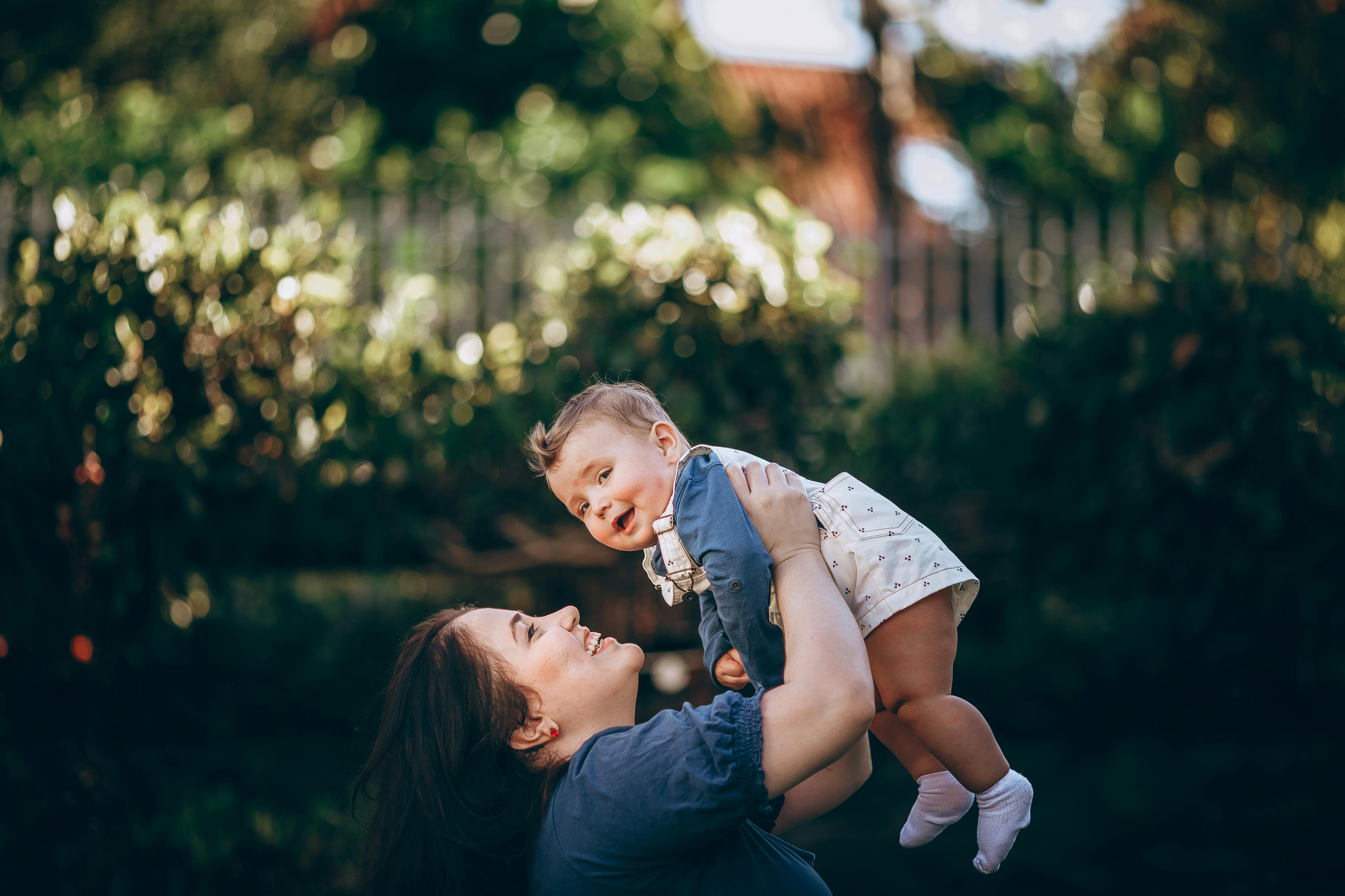 A woman holding her baby up in the air