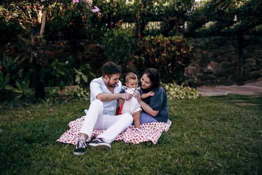 A joyful family enjoying a relaxing picnic in a lush garden setting.