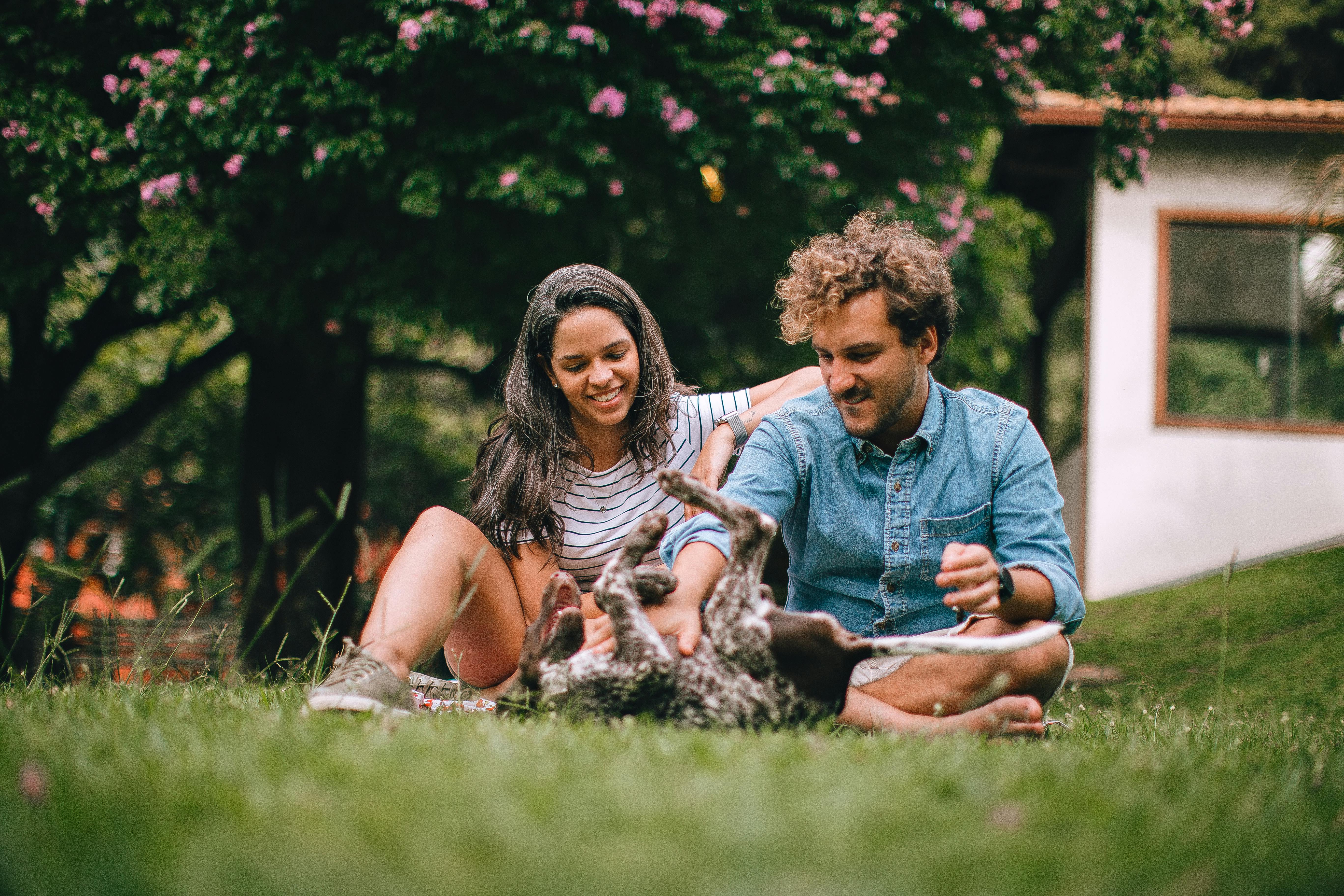 Couple sitting on grass with dog