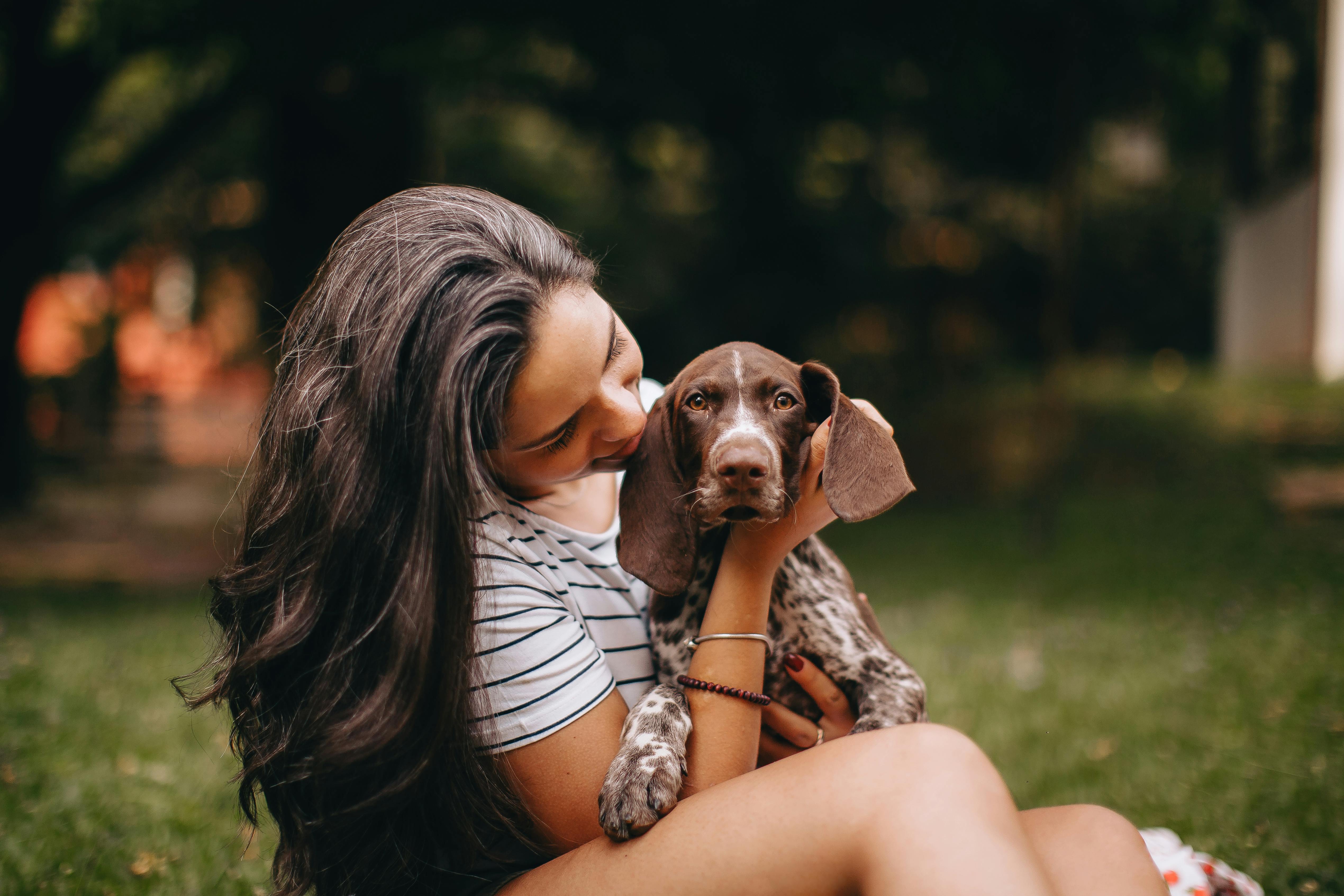 A woman is holding a dog in her arms